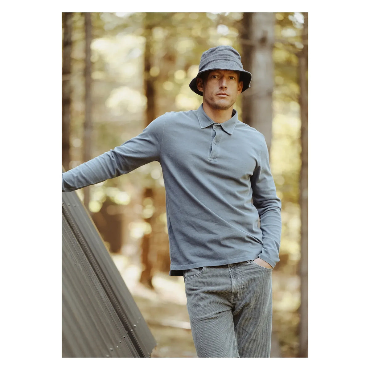 Men's long-sleeve organic recycled navy polo shirt by Save Khaki United, shown on a hanger against a plain background.