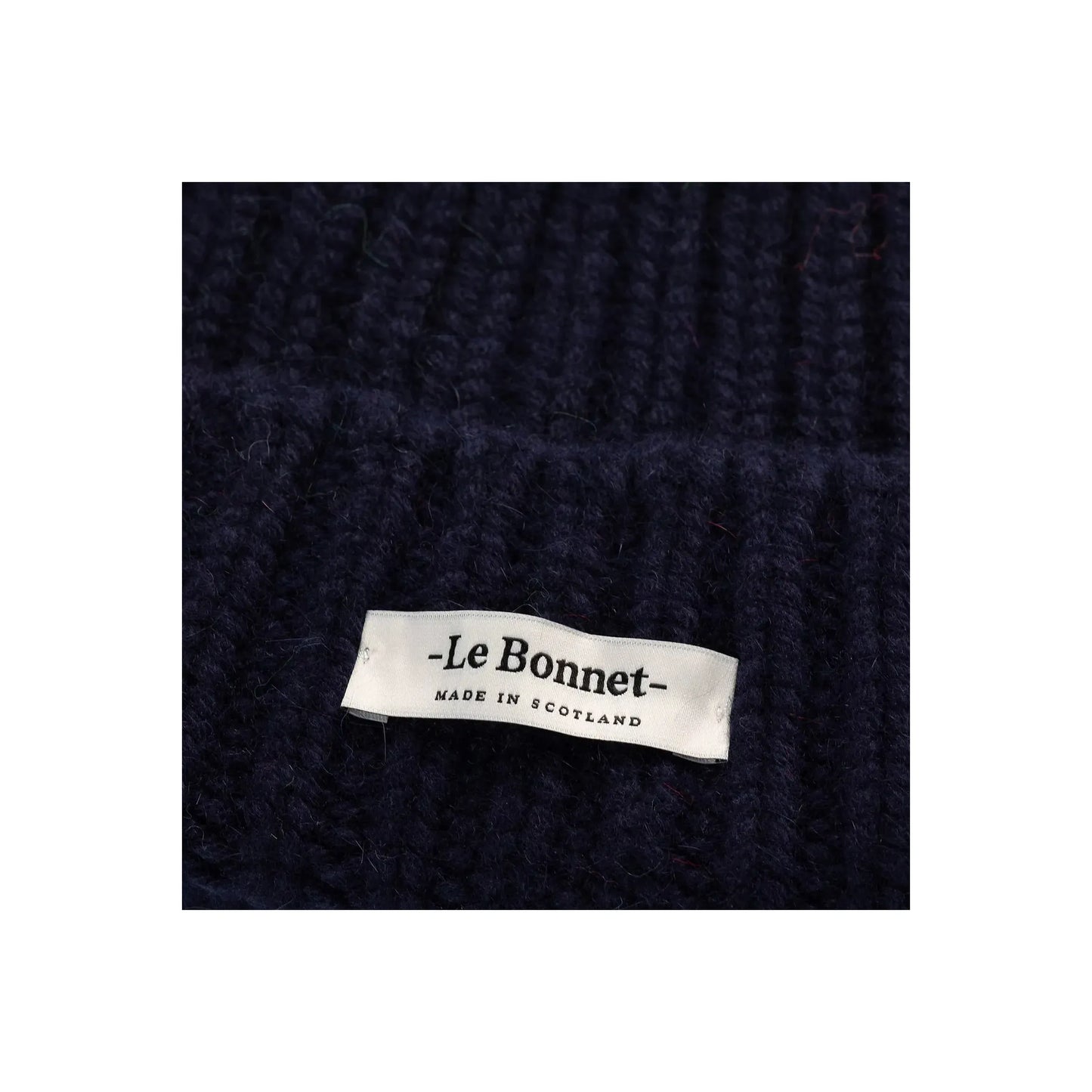 Women's Le Bonnett Logo Beanie in midnight color, close-up of soft knit fabric and embroidered logo detailing.