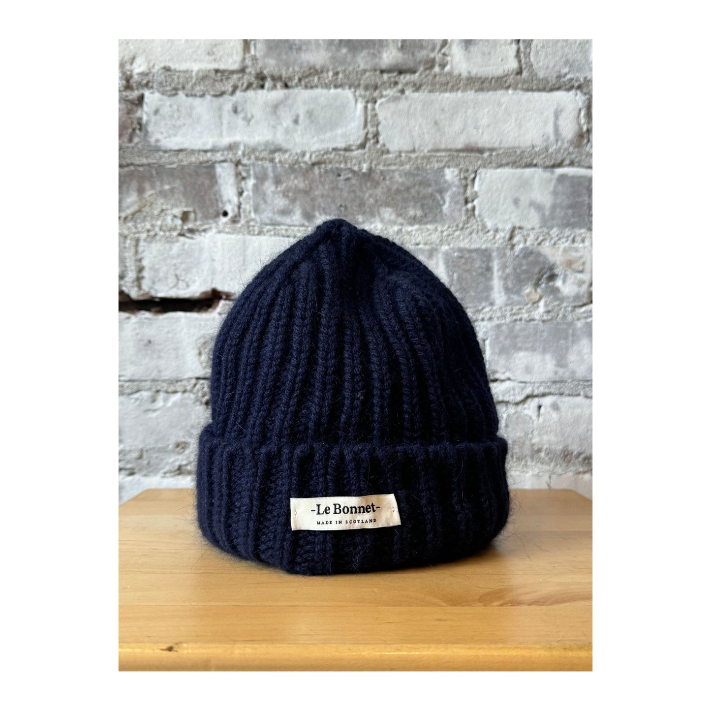 Women's Le Bonnett Logo Beanie in midnight color, featuring a branded patch on soft knit fabric.