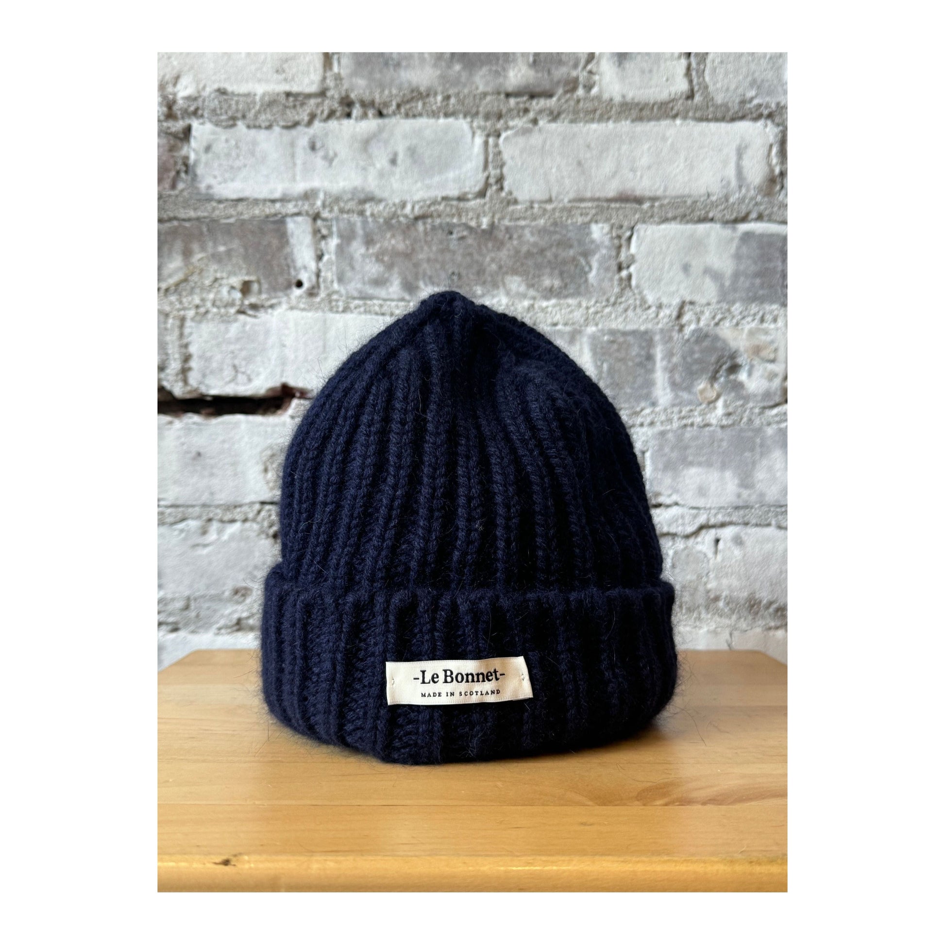 Women's Le Bonnett Logo Beanie in midnight color, featuring a branded patch on soft knit fabric.