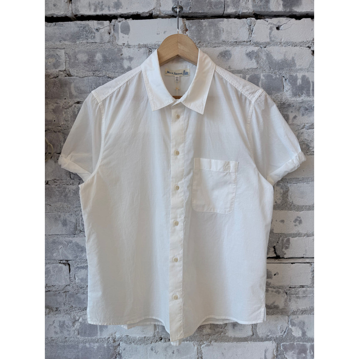White lightweight cotton poplin women's shirt with rolled-up sleeves by Merz b. Schwanen, shown on a hanger.
