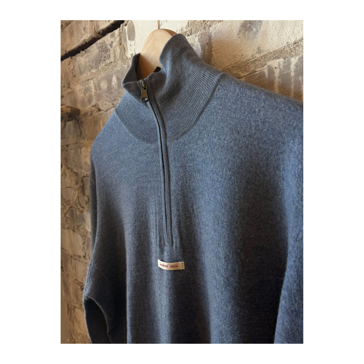 Men's boiled denim blue half zip sweater by Amundsen, showing the textured fabric and half zip collar detail.