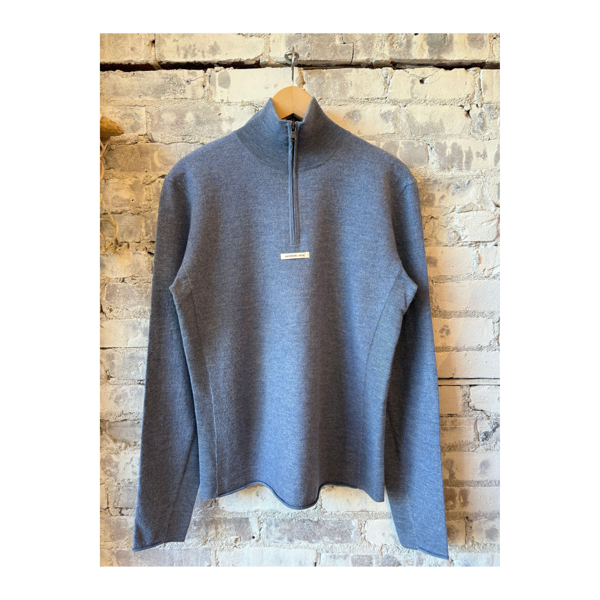 Men's boiled denim blue half zip sweater by Amundsen, featuring a close-up of the textured fabric and half zipper detail.