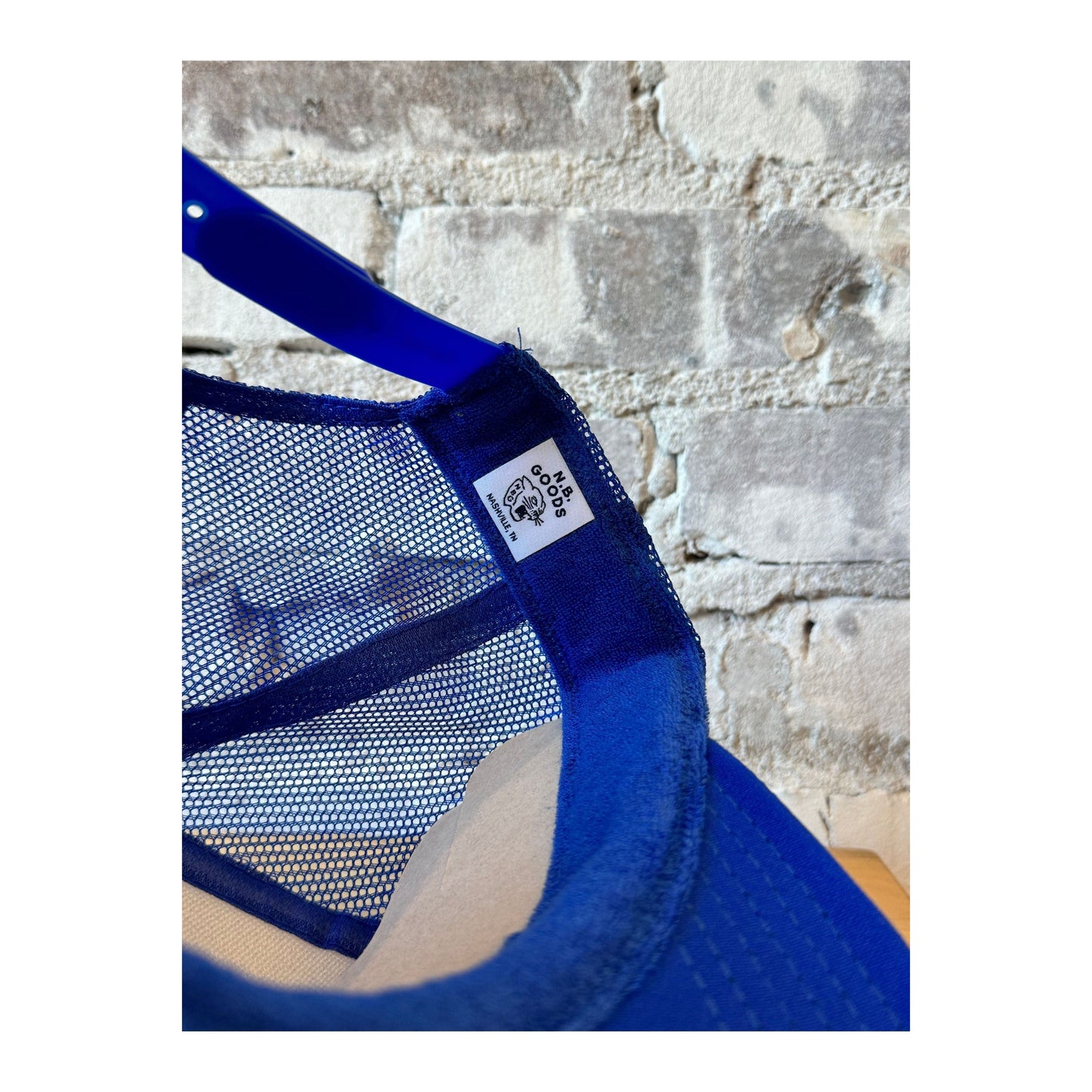 Royal blue trucker hat by N.B. GOODS featuring United States vs. Bruce Springsteen graphic and adjustable mesh back.
