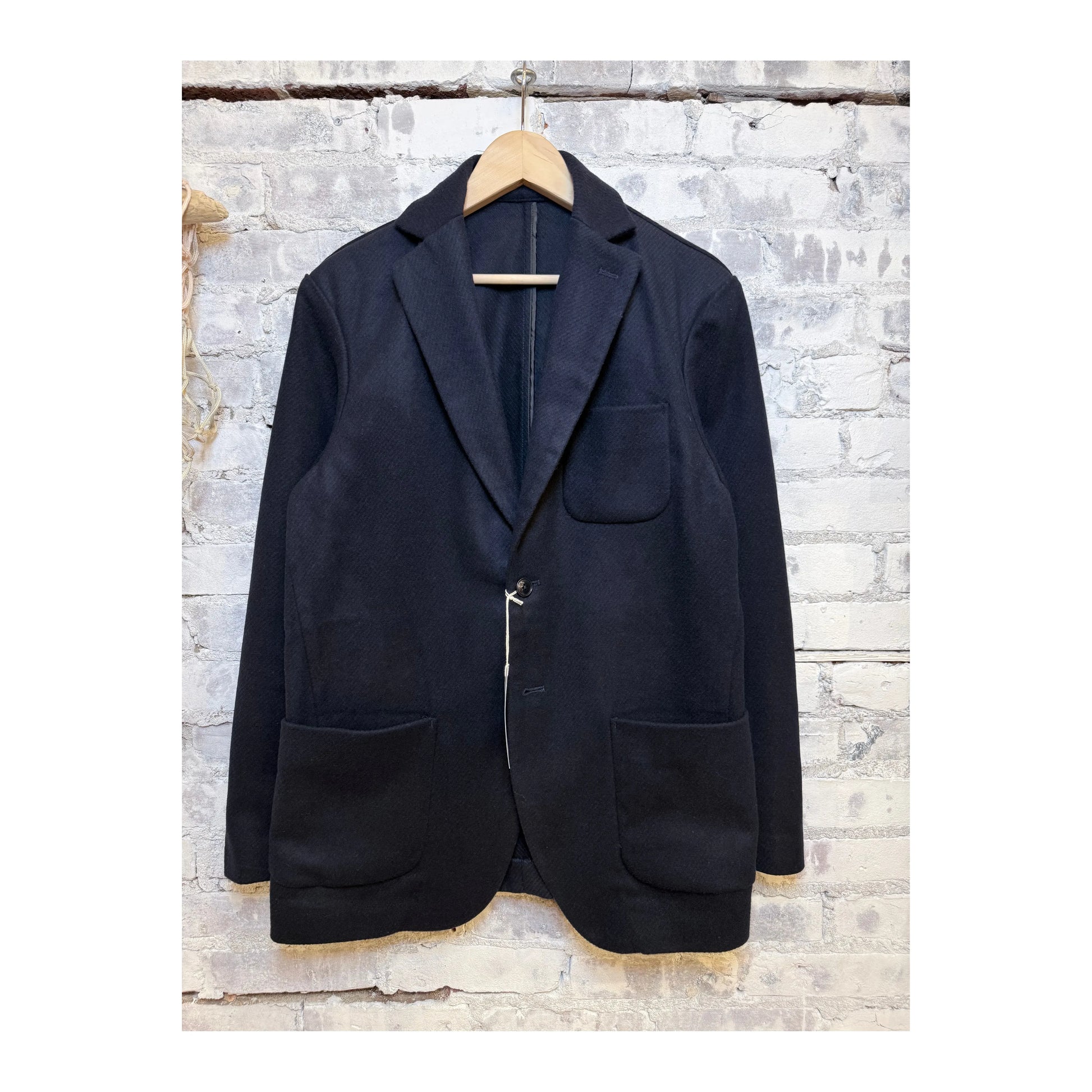 Men's dark navy N.O.UN jacket by Fujito, shown hanging with front view, featuring a sleek design and modern fit.