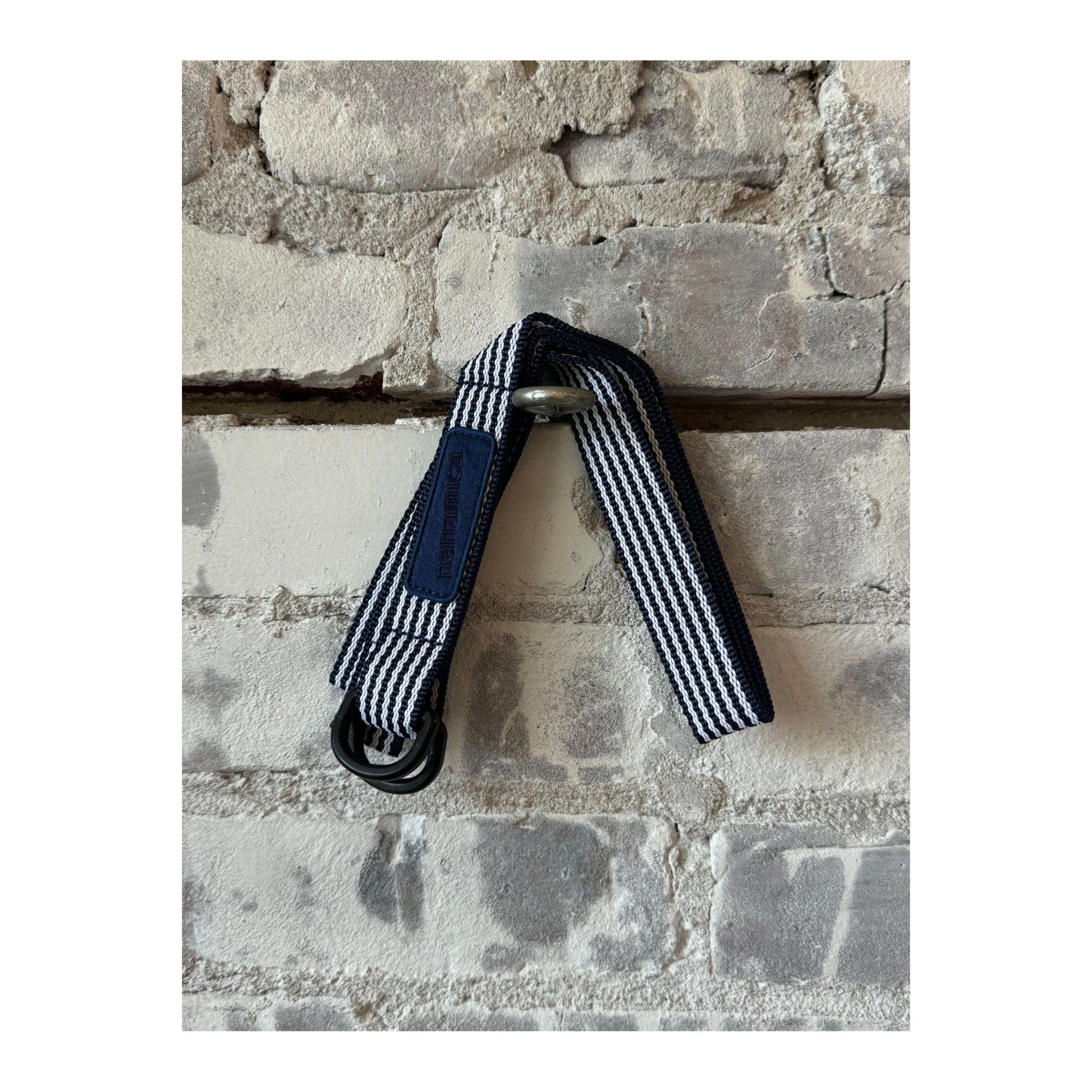Men's navy stripe tech belt by nanamica featuring a sleek, modern design with adjustable strap and metal buckle.
