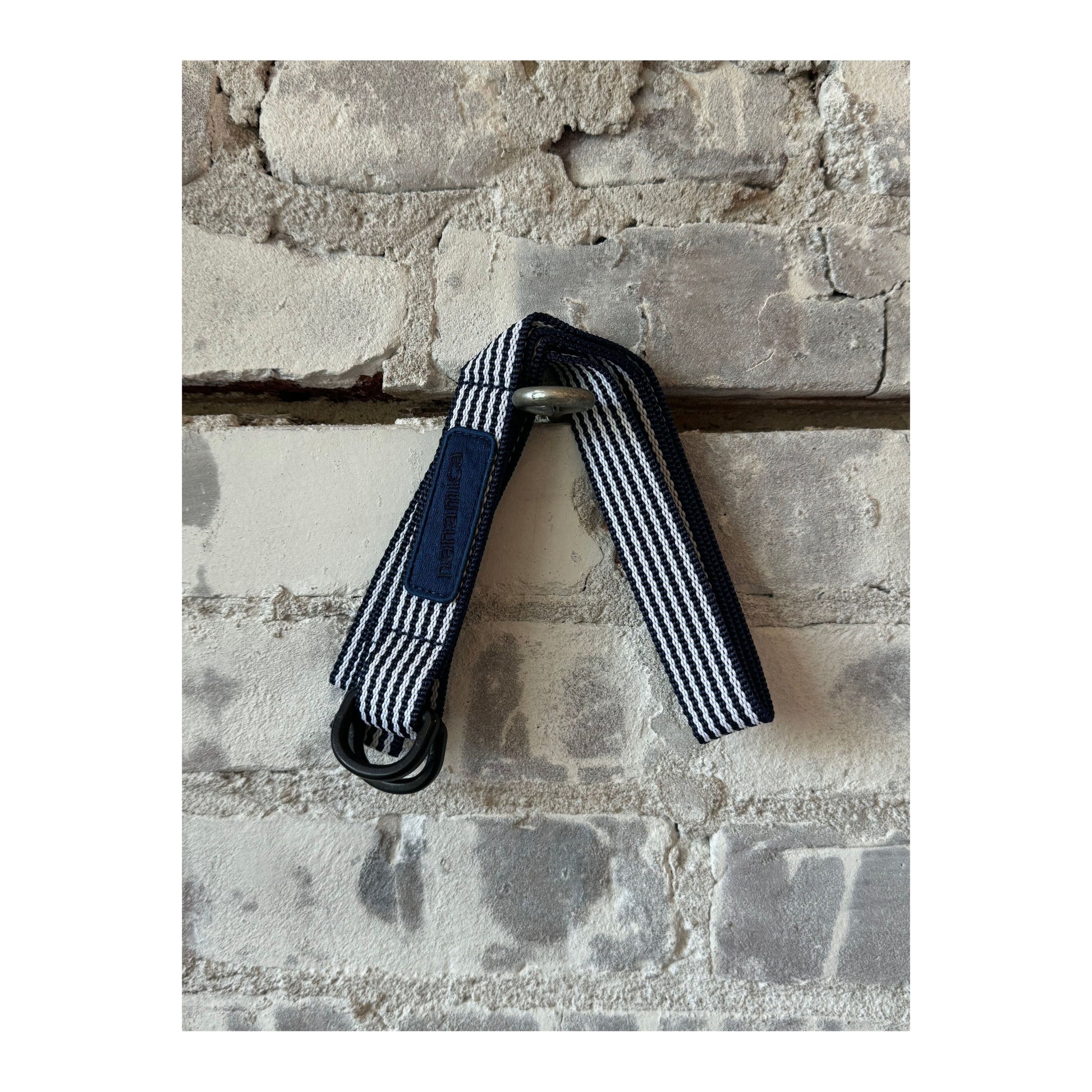 Men's navy stripe tech belt by nanamica featuring a sleek, modern design with adjustable strap and metal buckle.