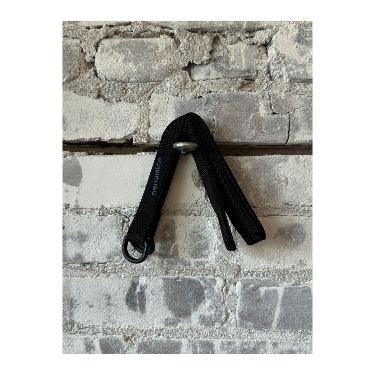 Black men's tech belt by nanamica, featuring durable fabric and sleek design, suitable for casual and outdoor wear.