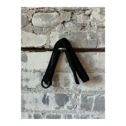 Black men's tech belt by nanamica, featuring durable fabric and sleek design, suitable for casual and outdoor wear.
