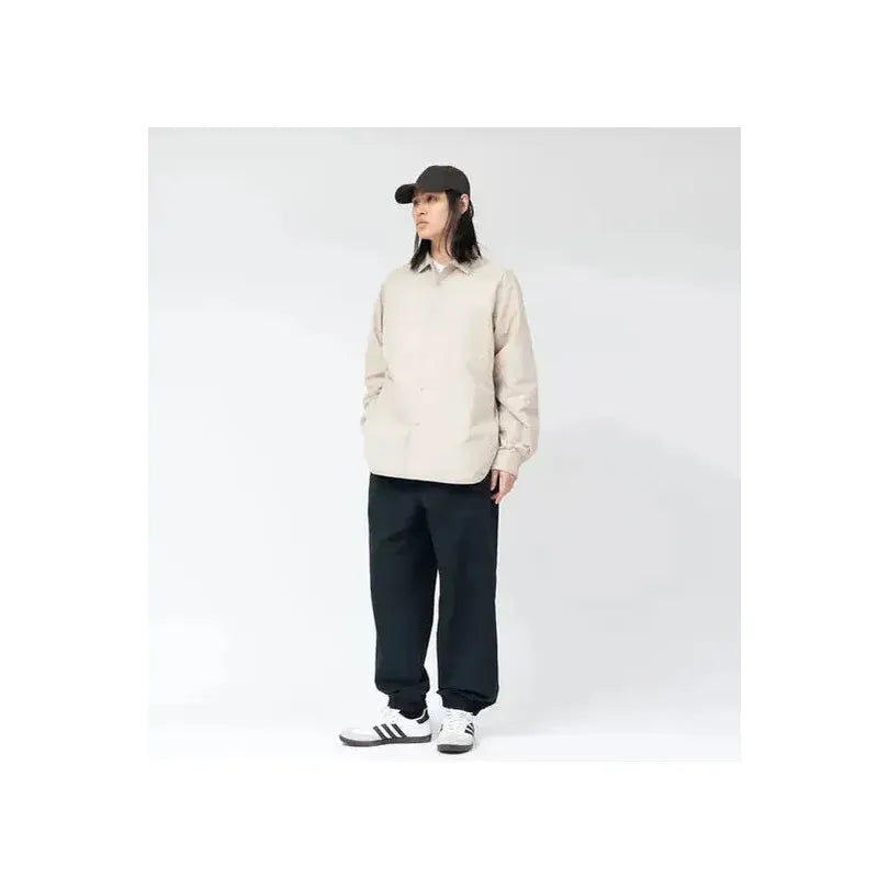 Men's dark navy insulation shirt jacket by nanamica, showcasing the insulated lightweight outerwear with a sleek design.