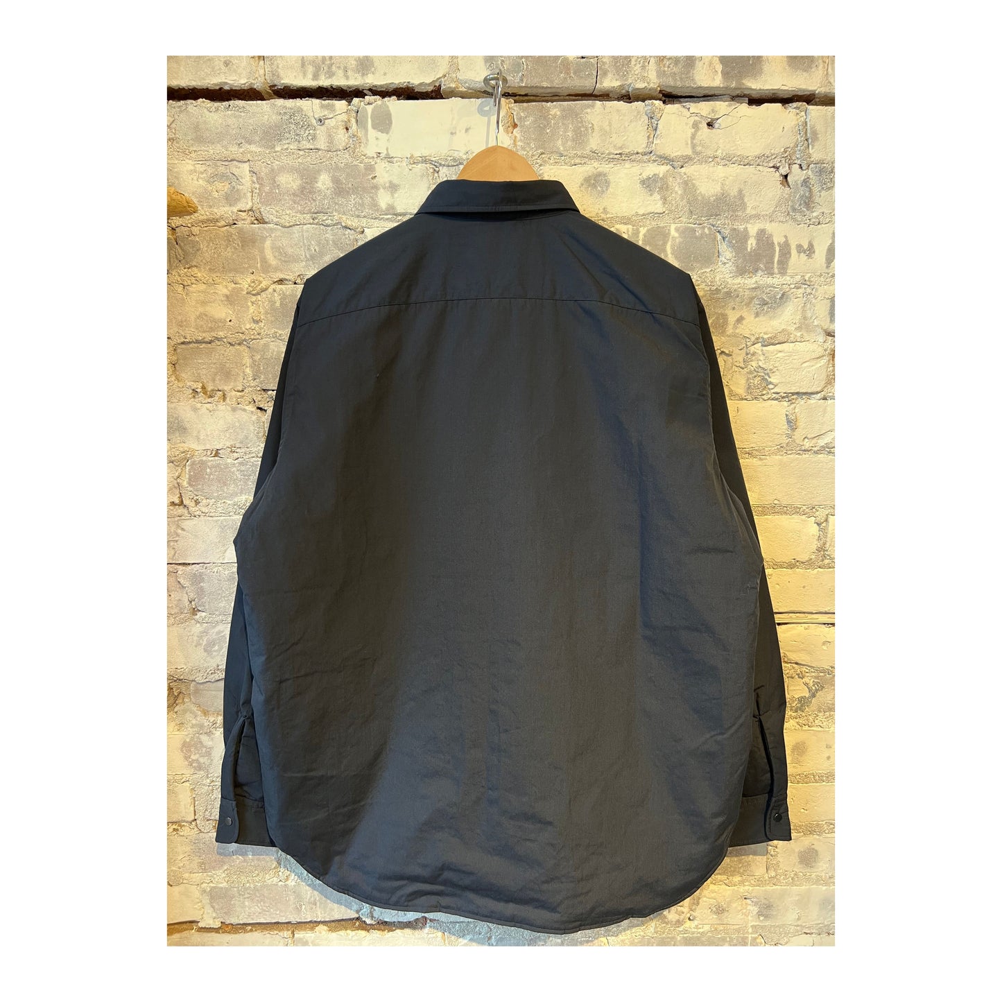 Men's nanamica insulation shirt jacket in dark navy, showing the lightweight, quilted design with a high collar and front button closure.