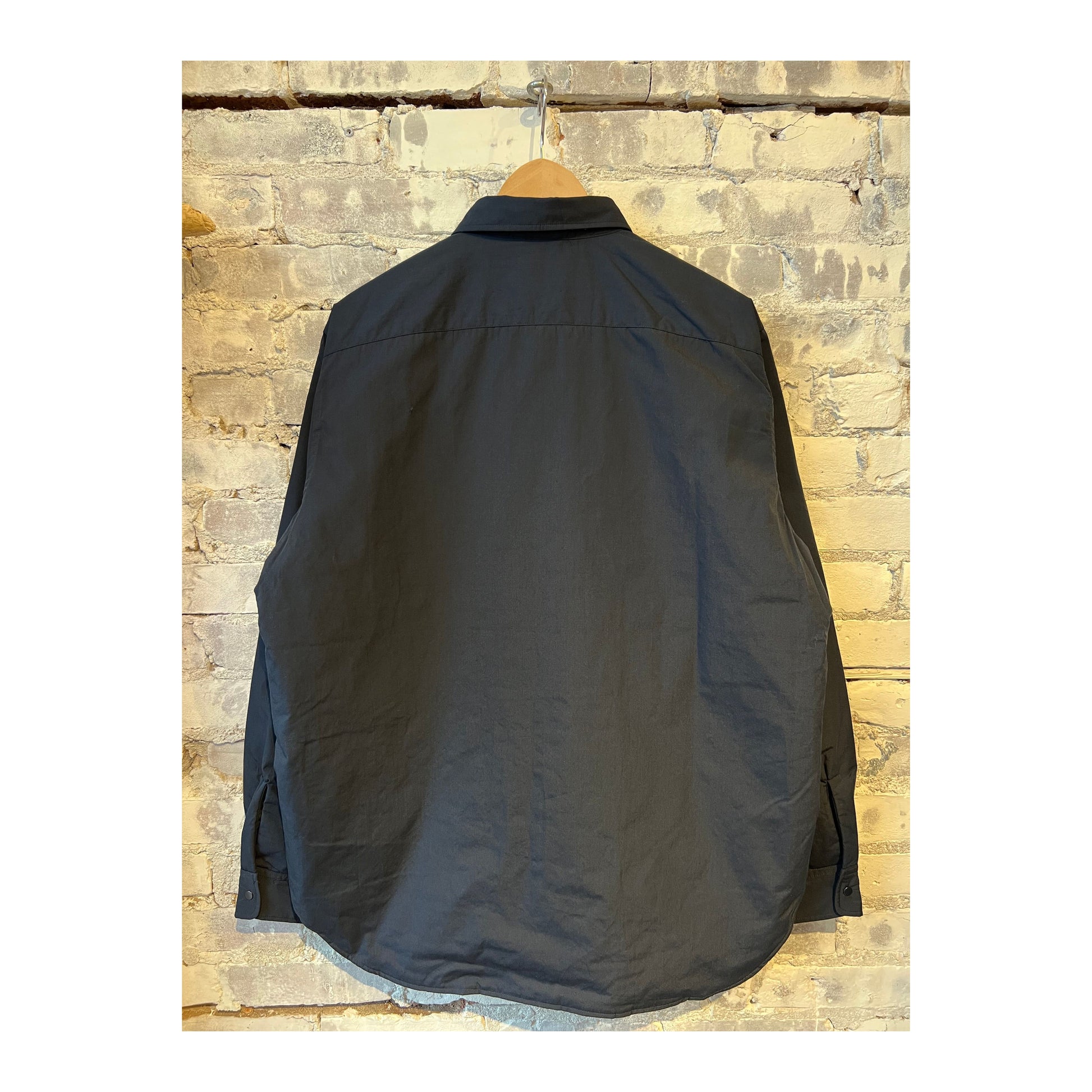 Men's nanamica insulation shirt jacket in dark navy, showing the lightweight, quilted design with a high collar and front button closure.