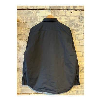 Men's nanamica insulation shirt jacket in dark navy, showing the lightweight, quilted design with a high collar and front button closure.