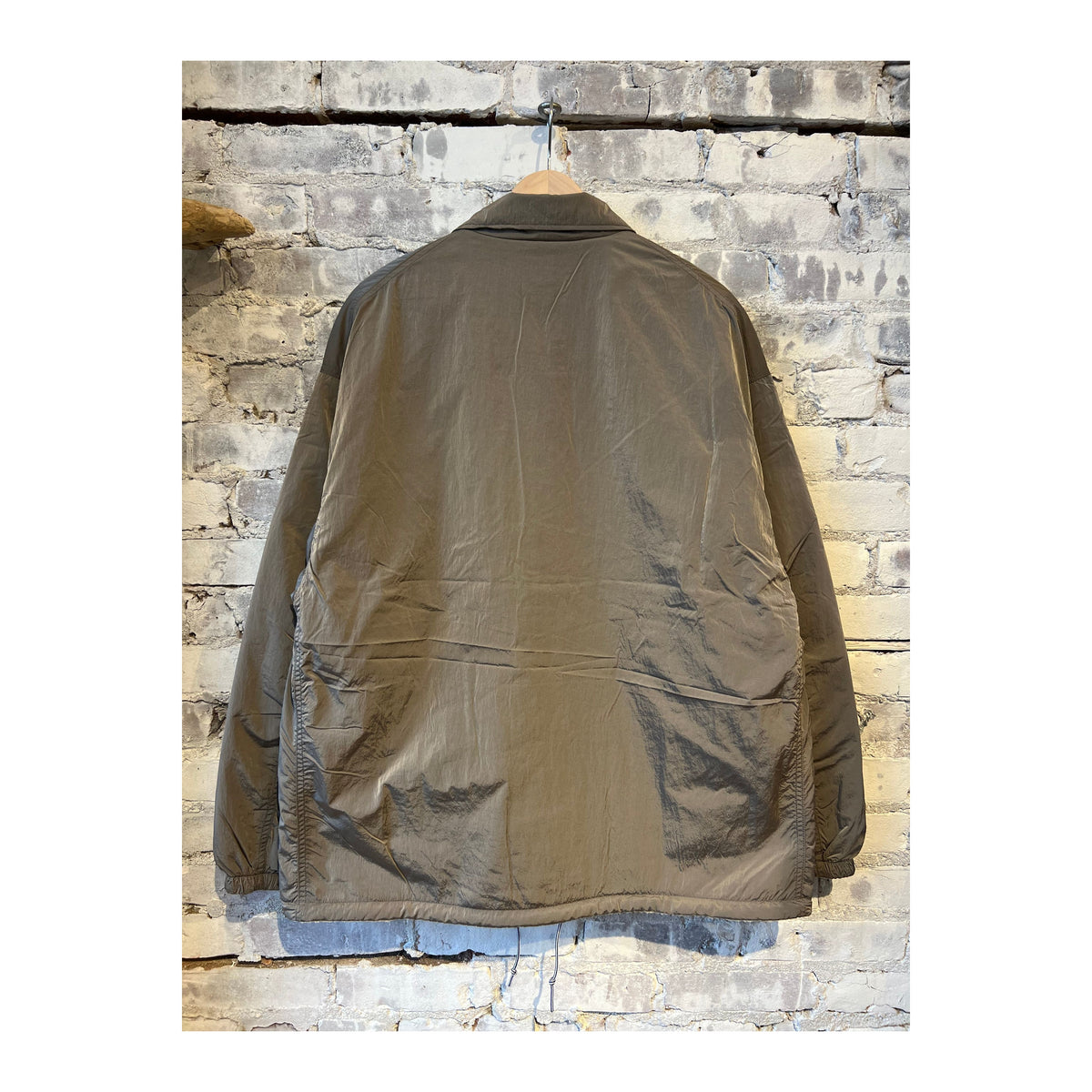 Men's beige reversible wind jacket by nanamica, showing front and back views with lightweight, wind-resistant fabric.