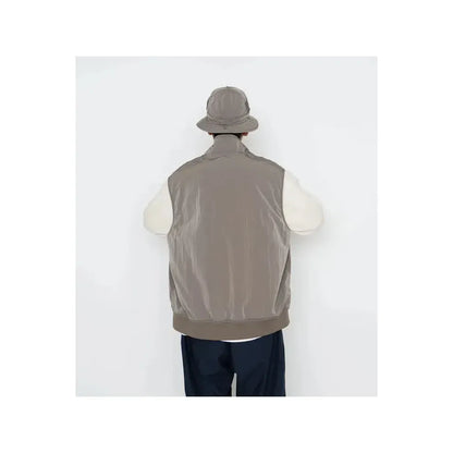Men's beige zip-up wind vest by nanamica, lightweight and wind-resistant, shown on a plain background.