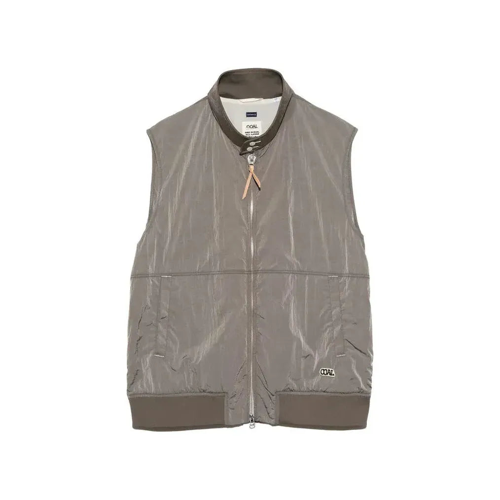 Men's beige nanamica zip-up wind vest with lightweight fabric and stand-up collar, designed for outdoor layering.
