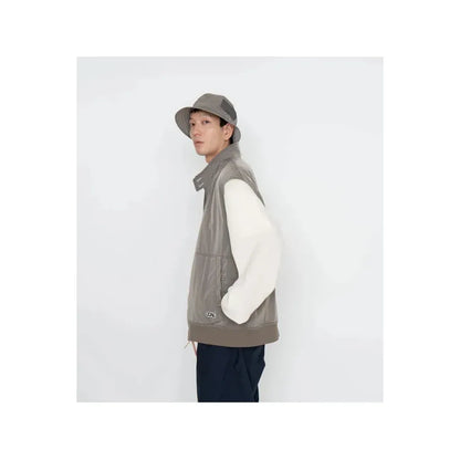 Men's beige nanamica zip-up wind vest with lightweight, breathable fabric, shown on a mannequin for outdoor wear.