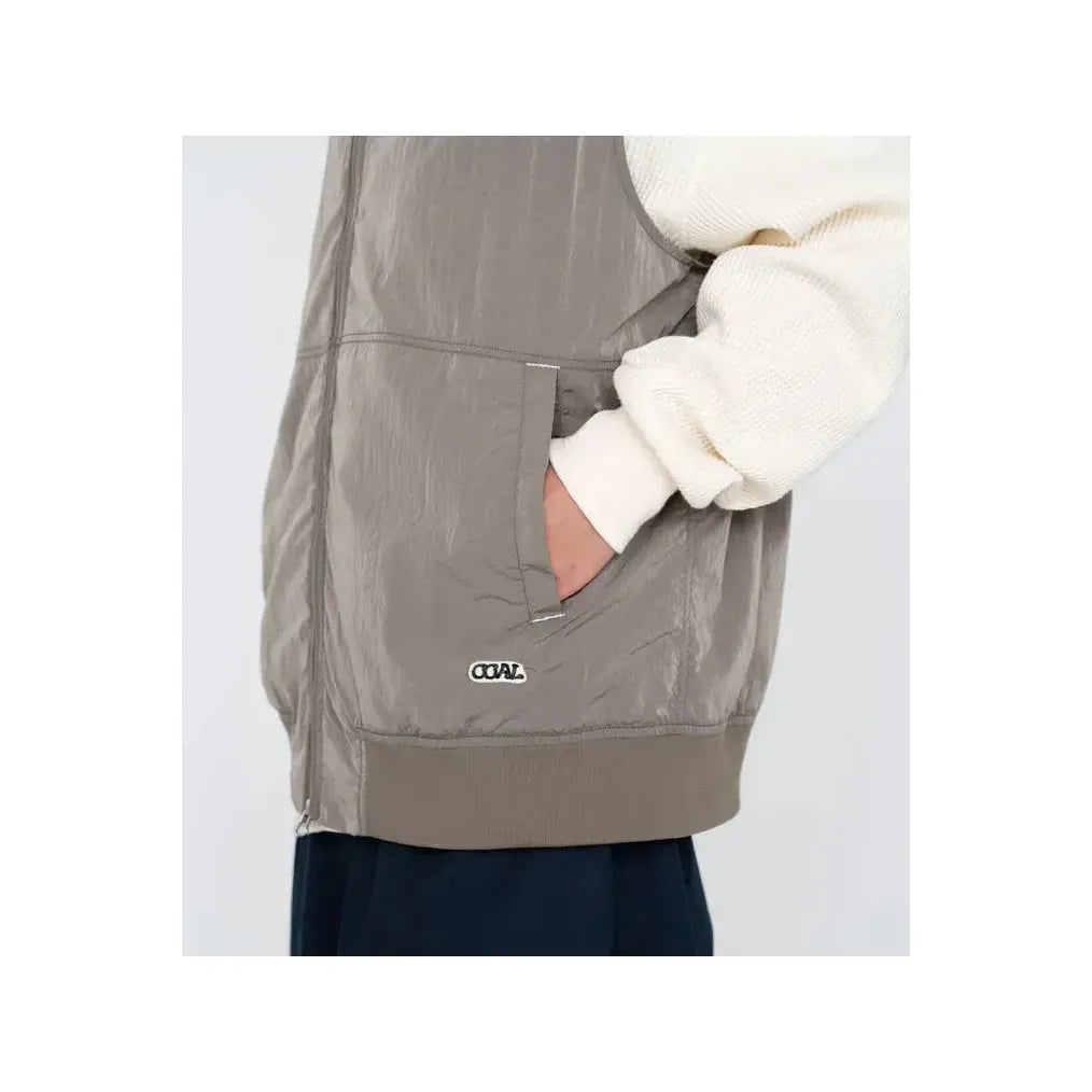 Men's beige zip-up wind vest by nanamica, lightweight outerwear with a stand collar and front zipper closure.