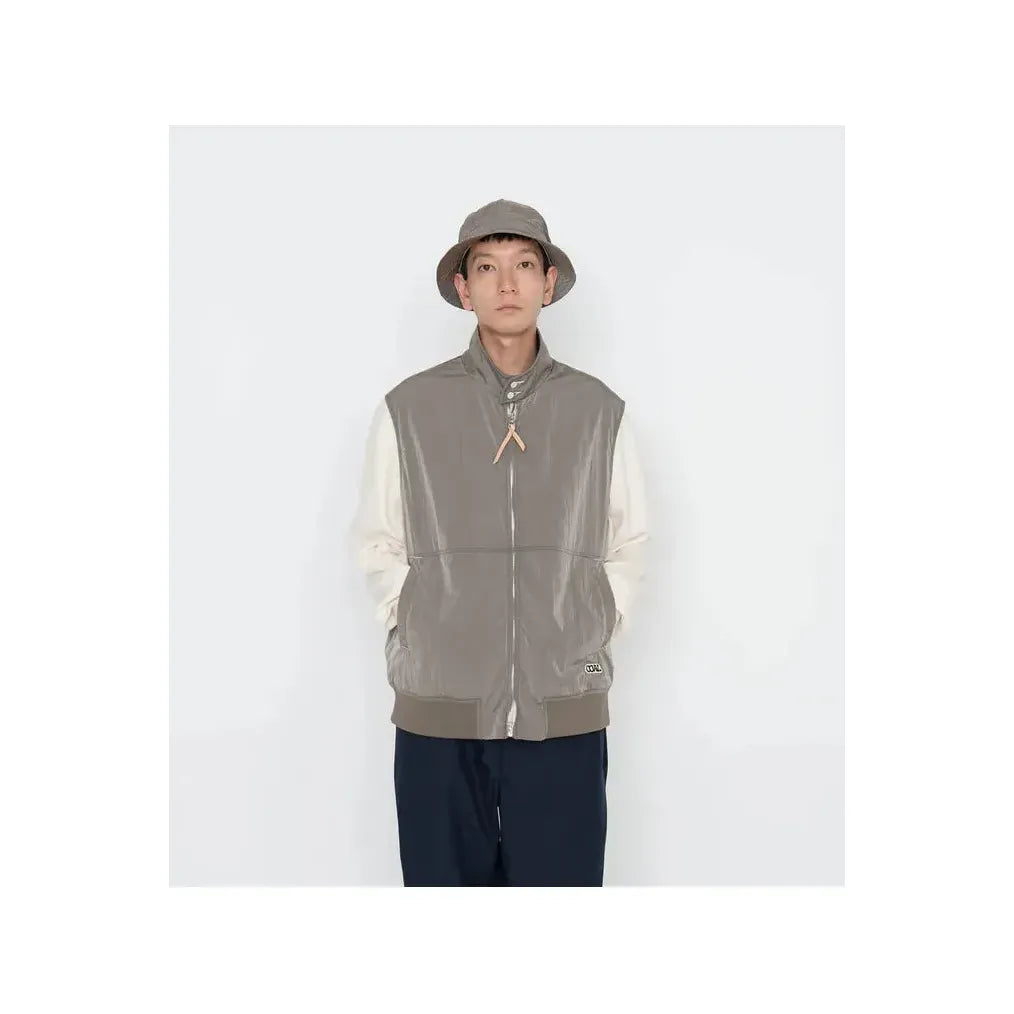 Men's beige nanamica zip-up wind vest with lightweight fabric and a stand-up collar, perfect for outdoor layering.