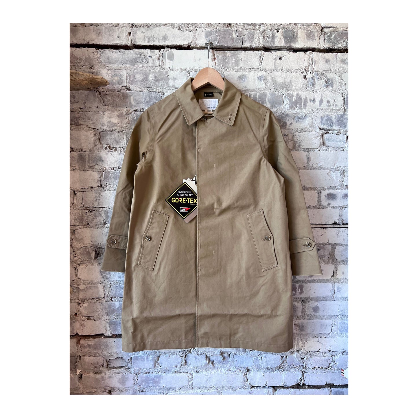 Women's beige GORE-TEX Soutien Collar coat by nanamica, showing the stylish collar and waterproof fabric.
