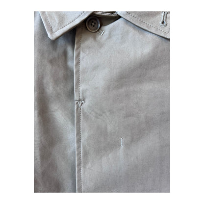 Women's beige nanamica GORE-TEX Soutien Collar Coat hanging on a hanger, showing its tailored collar and waterproof fabric.