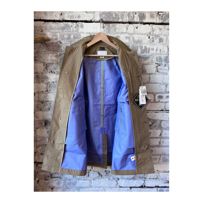 Women's beige nanamica GORE-TEX Soutien Collar Coat with a stylish collar and waterproof fabric, perfect for rainy weather.