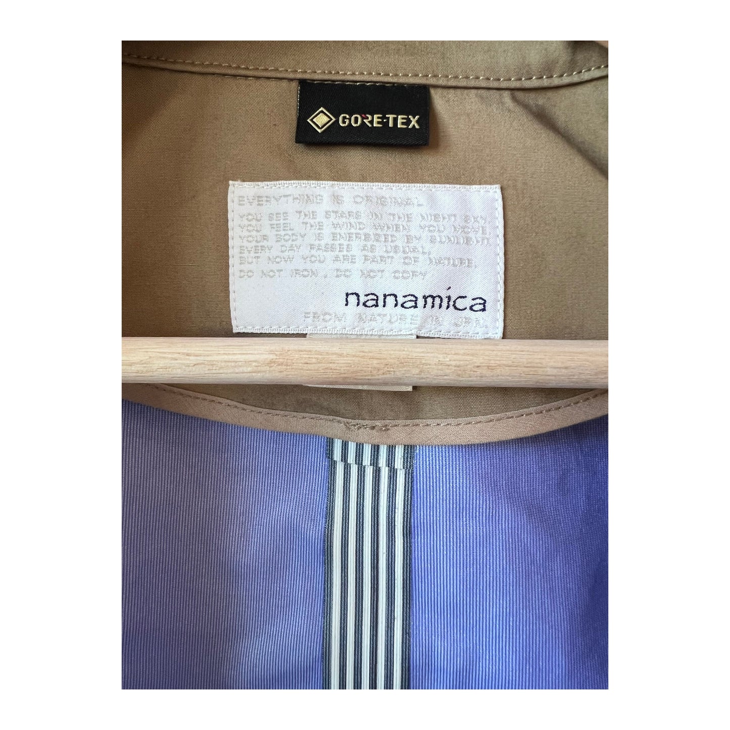 Women's beige GORE-TEX Soutien Collar Coat by nanamica, showcasing the coat's collar, waterproof fabric, and stylish design.