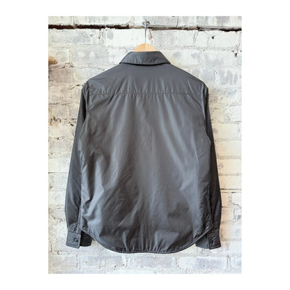 Women's grey padded nylon overshirt by Aspesi, shown in a close-up image highlighting the fabric texture and tailored fit.