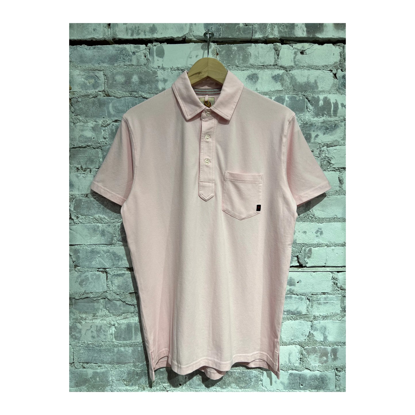 Men's pale pink Pique Slot Polo shirt by Relwen, showing the textured fabric and classic collar detail.