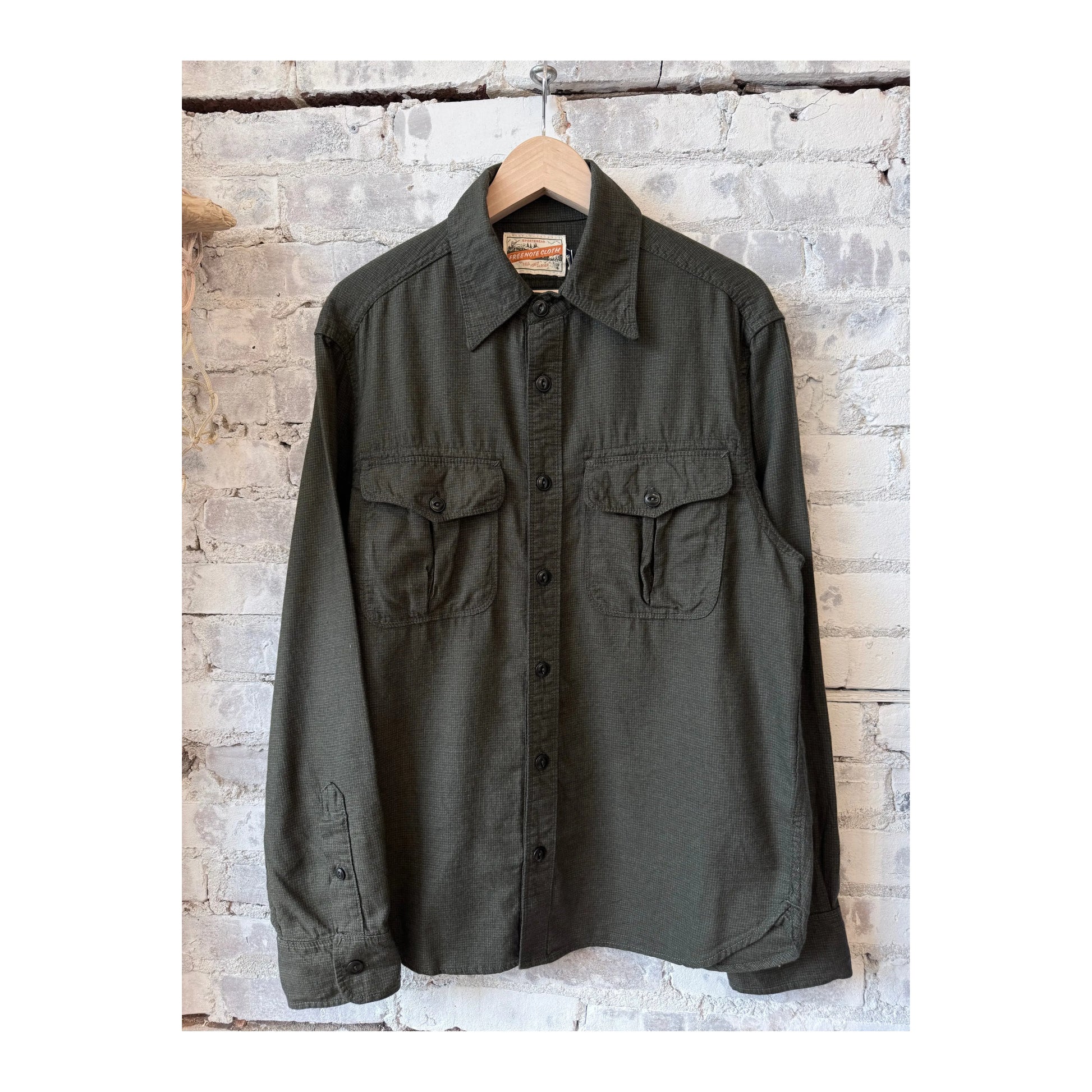 Men's Freenote Cloth Rancho Forest Check shirt with green and brown plaid pattern, shown on a hanger.