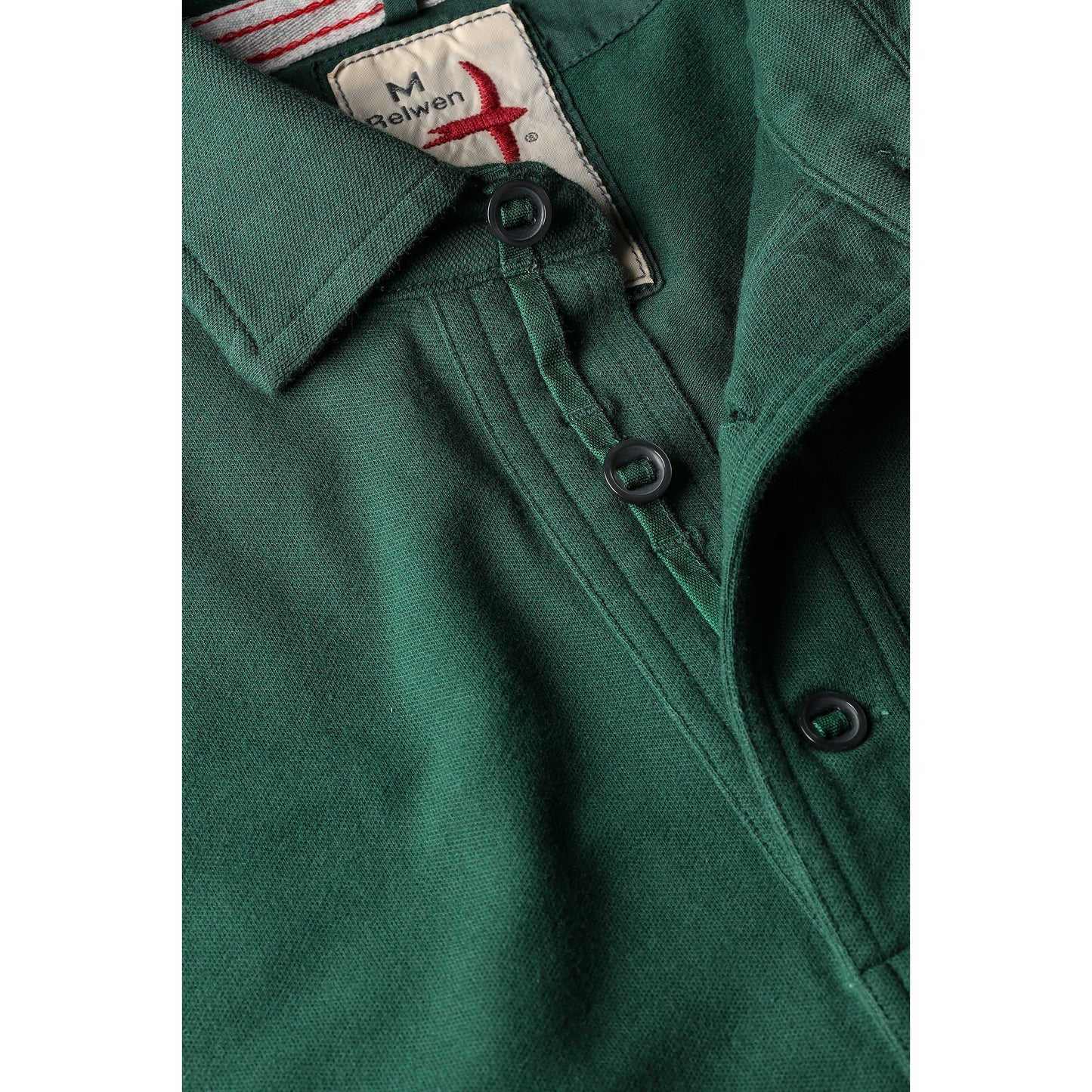 Men's forest green pique slot polo shirt by Relwen, showing a close-up of the textured fabric and classic collar detail.