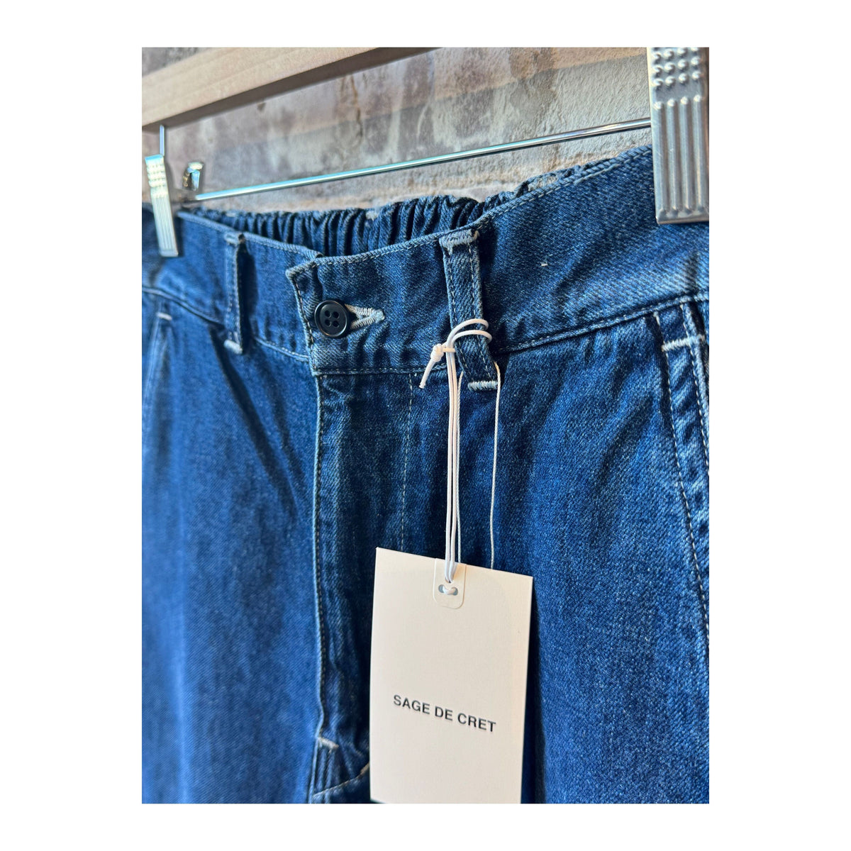 Men's indigo blue denim peg top pants by Sage De Cret, featuring a relaxed fit and classic style with visible stitching.