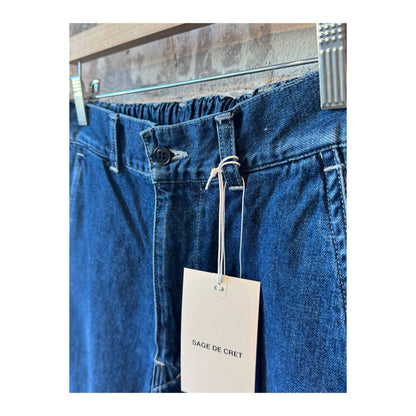 Men's indigo blue denim peg top pants by Sage De Cret, featuring a relaxed fit and classic style with visible stitching.