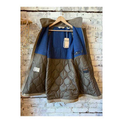 Aspesi men's Schaefer Canvas Car-Coat in dove grey hanging on a clothing rack, showcasing its stylish design and fabric texture.