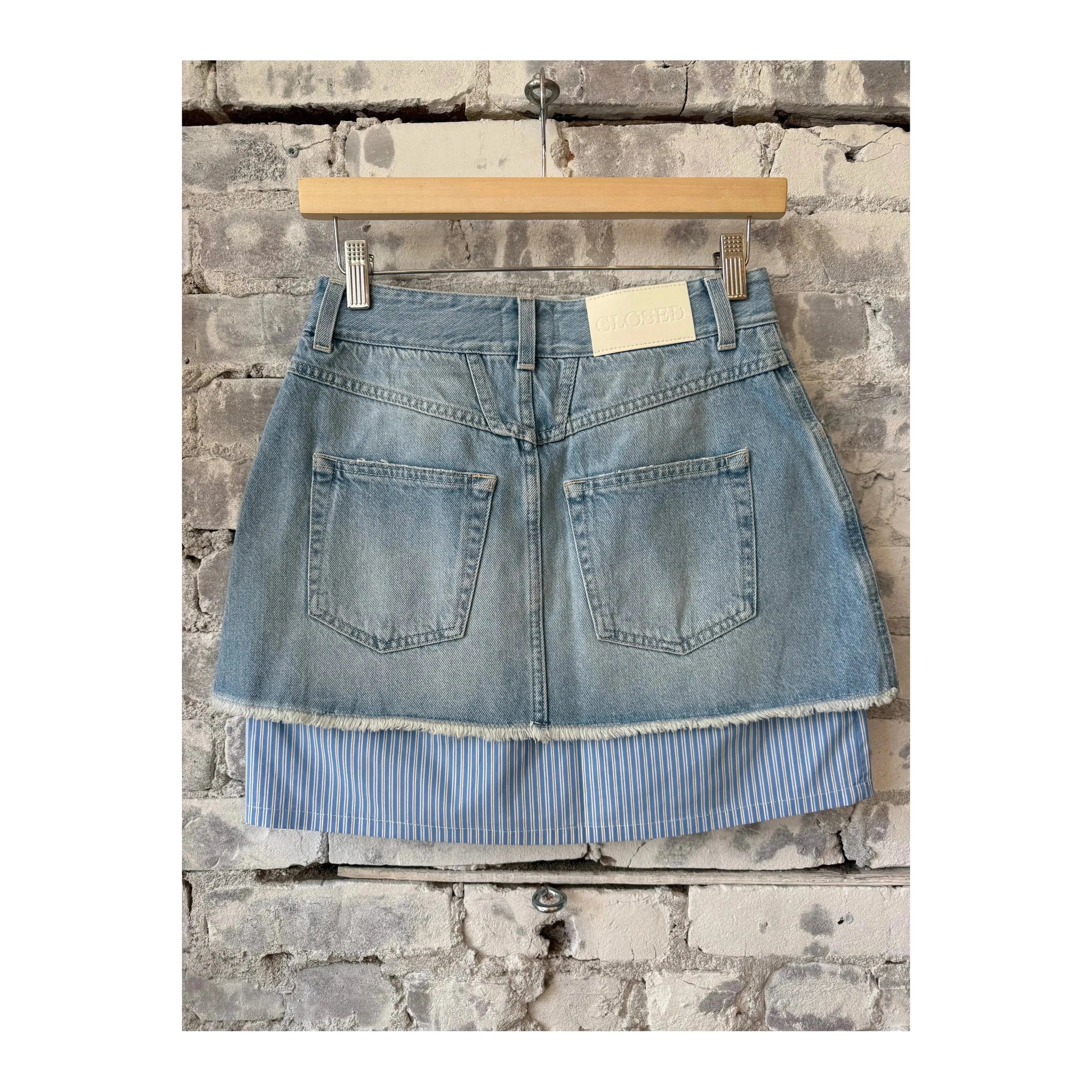 Light blue women's short denim poplin mini skirt by Closed Women's, shown laid flat highlighting the fit and fabric texture.