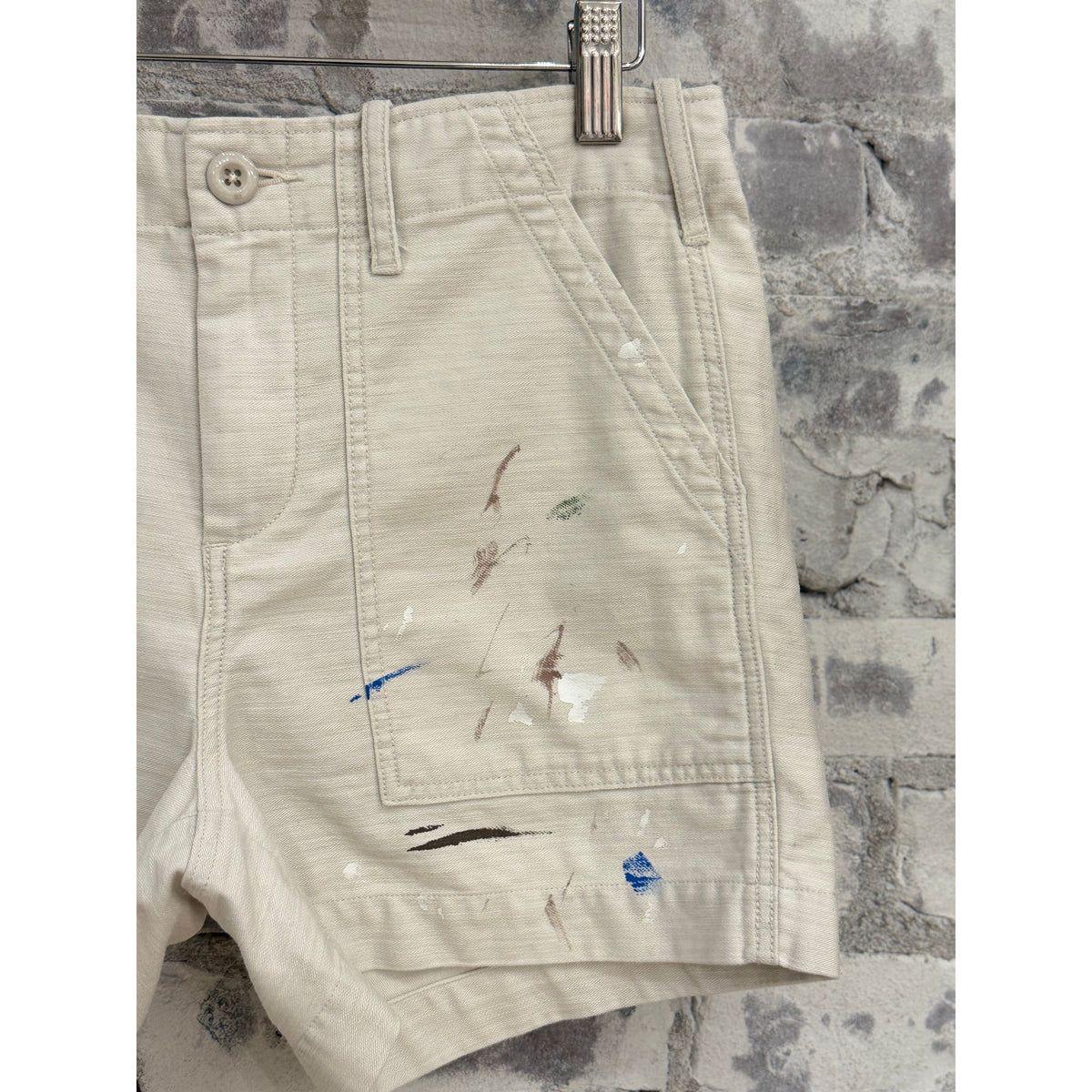 Women's Surplus Short Shorts with paint splatter design in canvas fabric by G1 Women's, shown on a model.