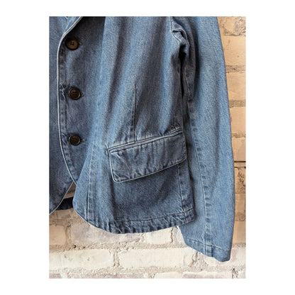 Women's faded blue denim blazer by Pas De Calais, tailored fit with classic collar and button closure, shown on a model.