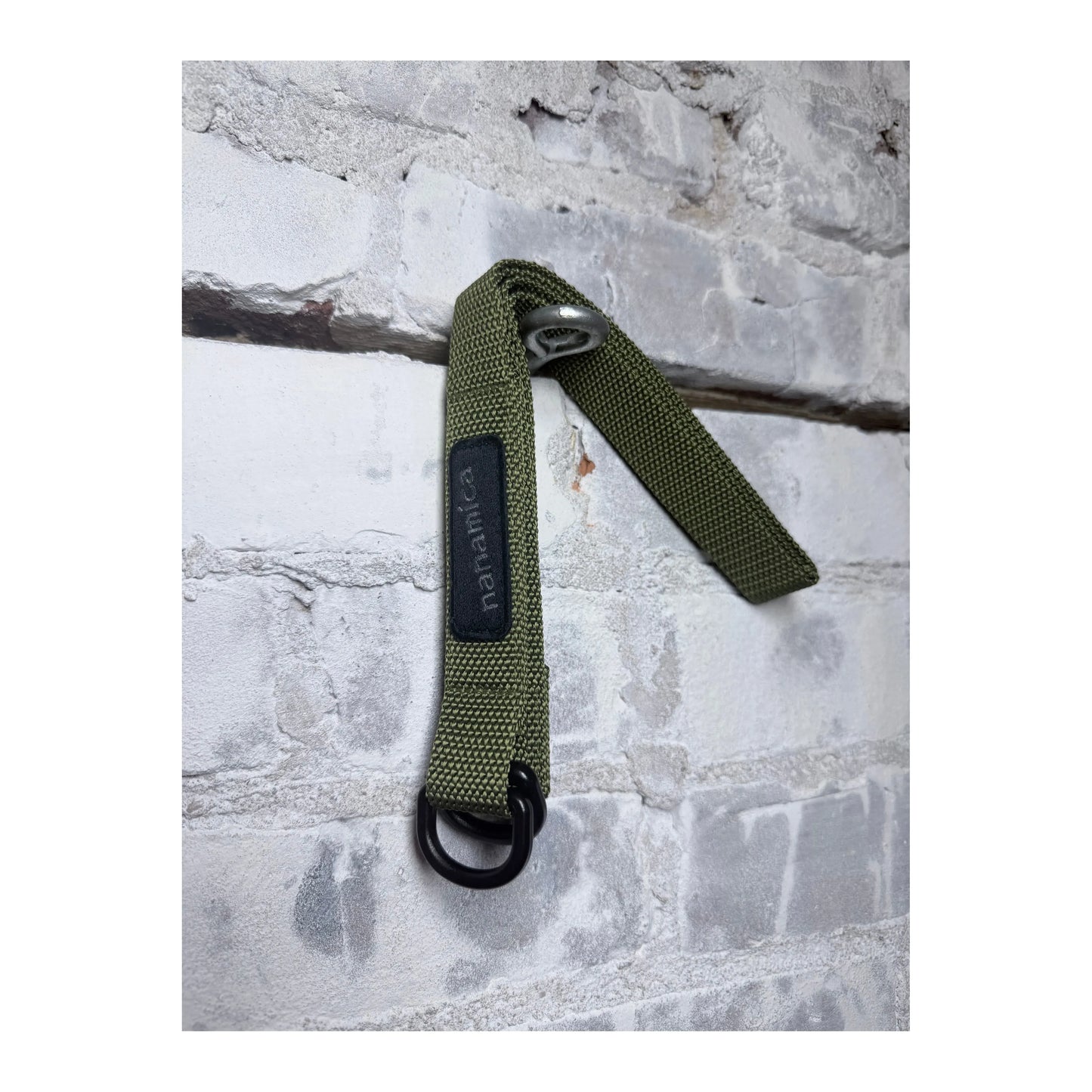 Men's khaki green tech belt by nanamica, featuring a durable strap with metal buckle, designed for casual and outdoor wear.