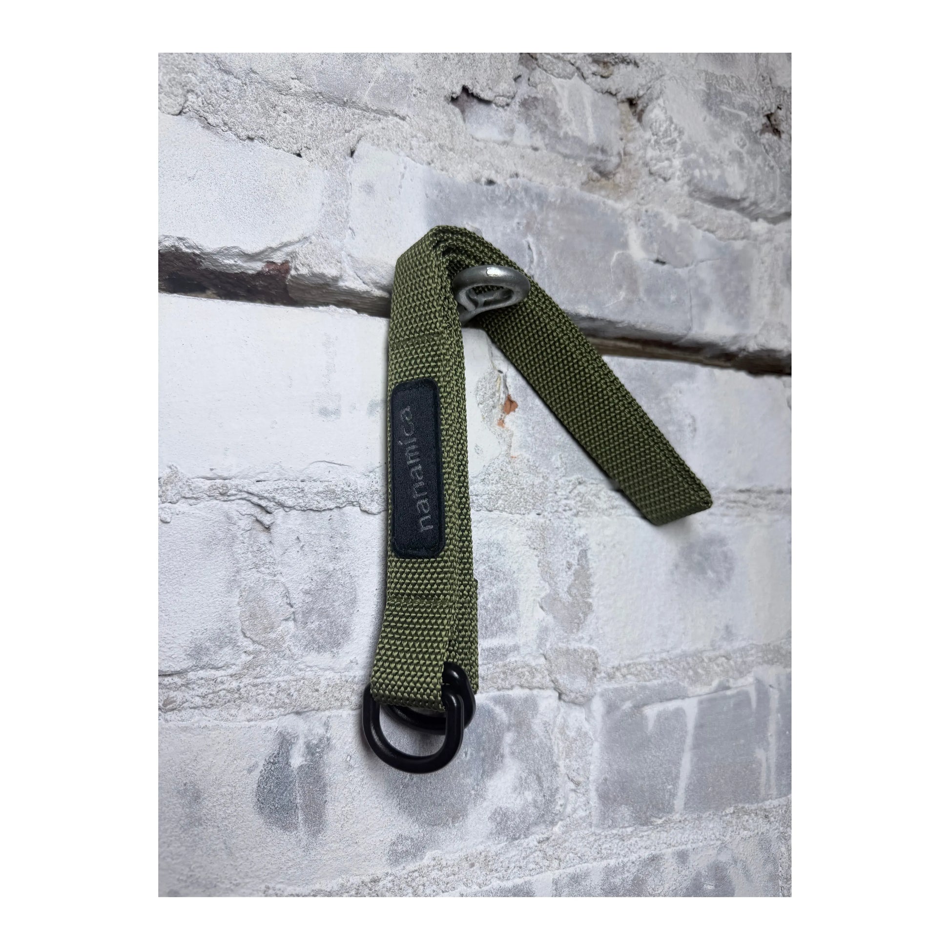 Men's khaki green tech belt by nanamica, featuring a durable strap with metal buckle, designed for casual and outdoor wear.