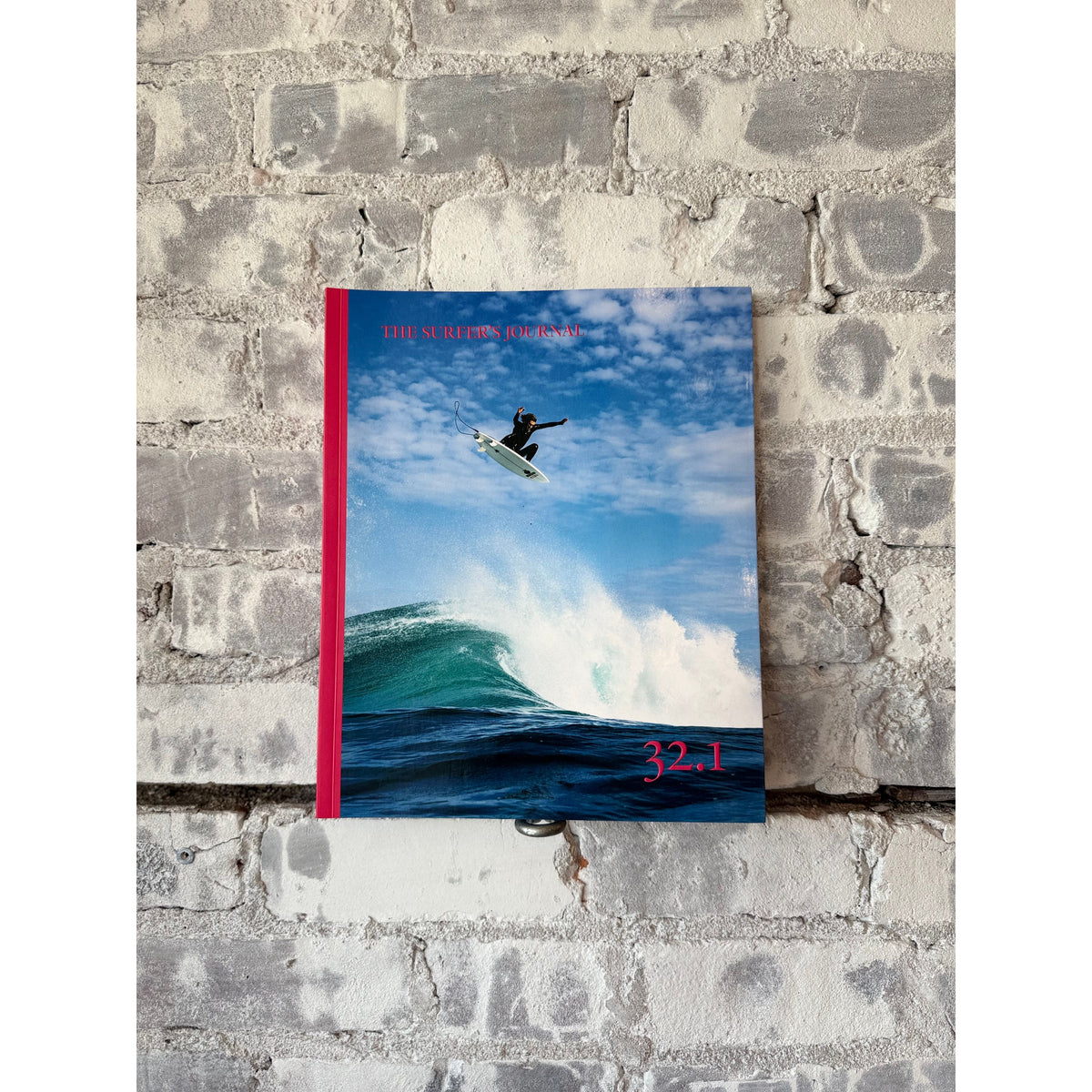 Open copy of The Surfer's Journal 32 editions, featuring magazine covers and surf-themed home accessories.