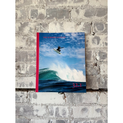 Open copy of The Surfer's Journal 32 editions, featuring magazine covers and surf-themed home accessories.