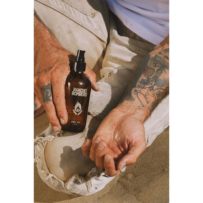 Rancho Bombero Total Body Oil 8 oz. bottle showing the sleek glass container with a pump dispenser and label.