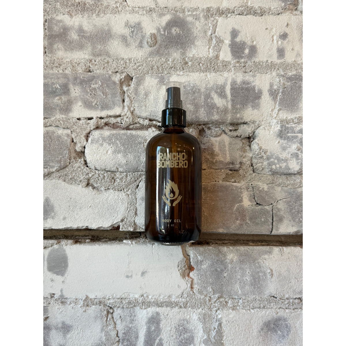 Rancho Bombero Total Body Oil 8 oz. bottle, natural skincare accessory with a sleek design and label, for nourishing skin.