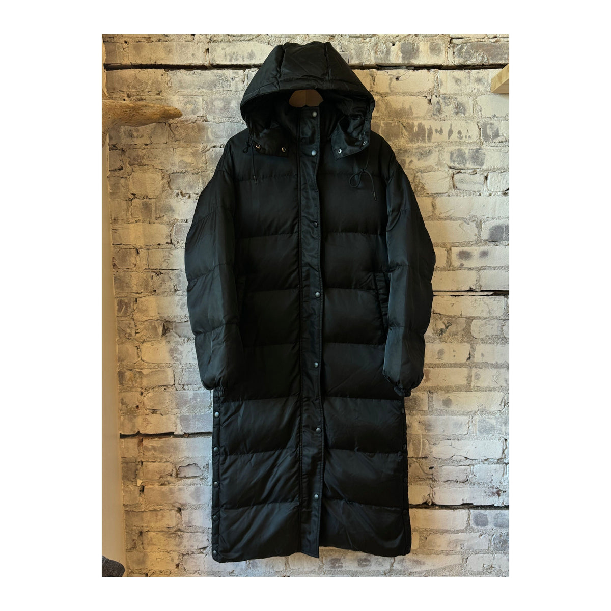 Women's long puffer jacket by TWIN in black and royal blue, featuring a warm, quilted design with a high collar.