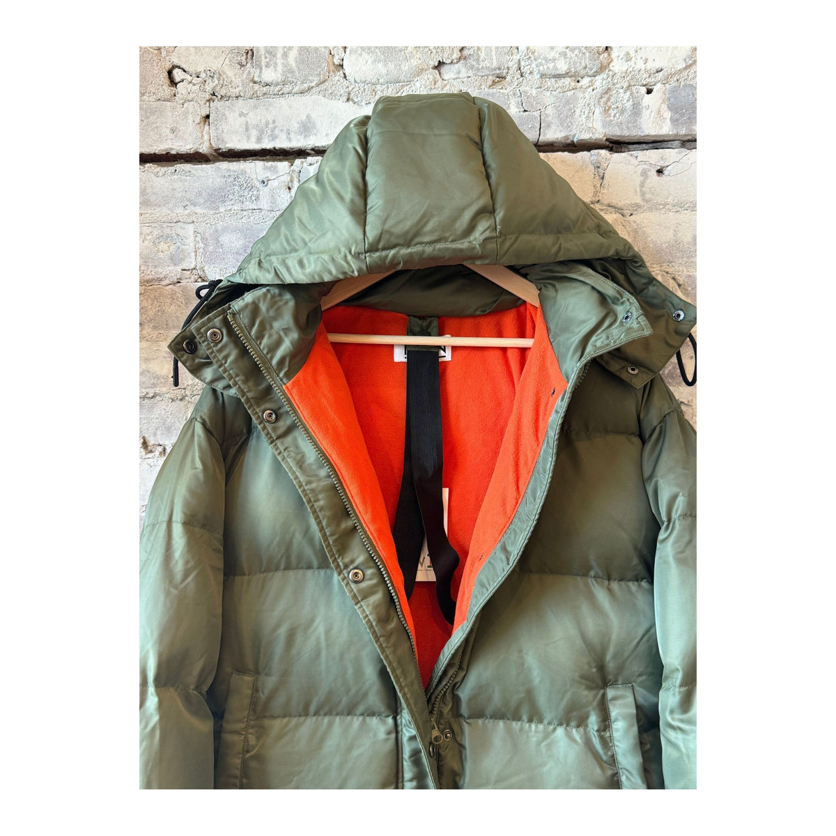Women’s long puffer jacket in military orange by TWIN, featuring a warm, insulated design with a high collar and quilted texture.