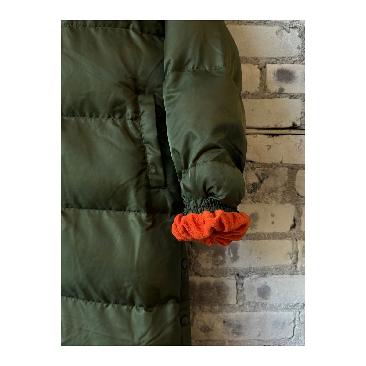 Women's TWIN 06 Long Puffer Coat in military orange, featuring a trendy, insulated design for cold weather comfort.