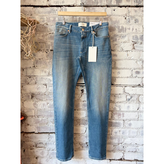 Men's Unity Slim Jean in mid blue by Closed Men's, showing a close-up of the slim fit denim with classic stitching and five-pocket design.