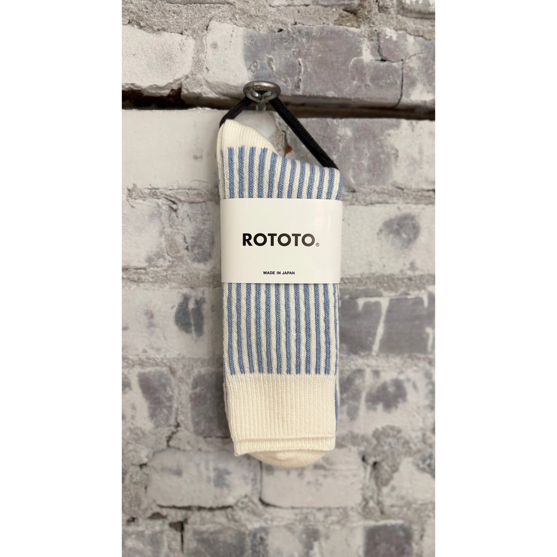 Men's vertical striped white and light blue socks by Rototo, showcasing the colorful pattern and comfortable fit.