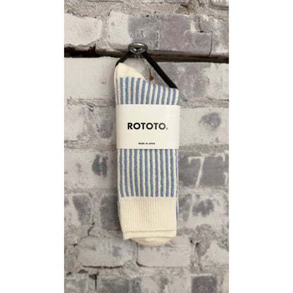 Men's vertical striped white and light blue socks by Rototo, showcasing the colorful pattern and comfortable fit.