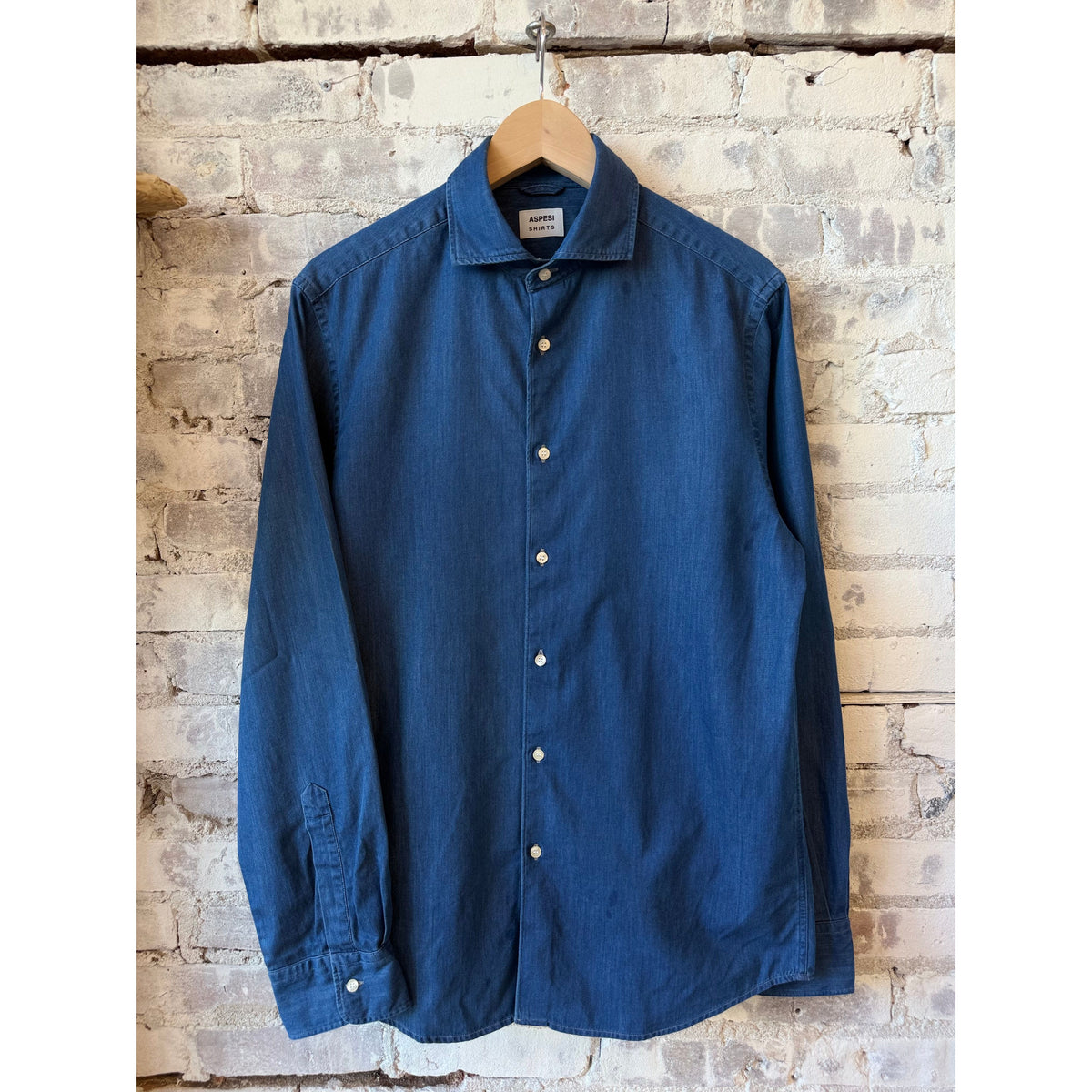 Men's Aspesi Vic Shirt in denim blue, featuring a classic fit and button-down design, displayed on a hanger.